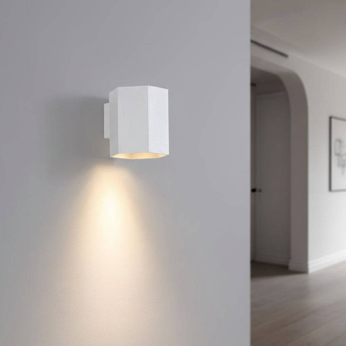 White interior LED wall downlight on a grey wall in a hallway of a modern house