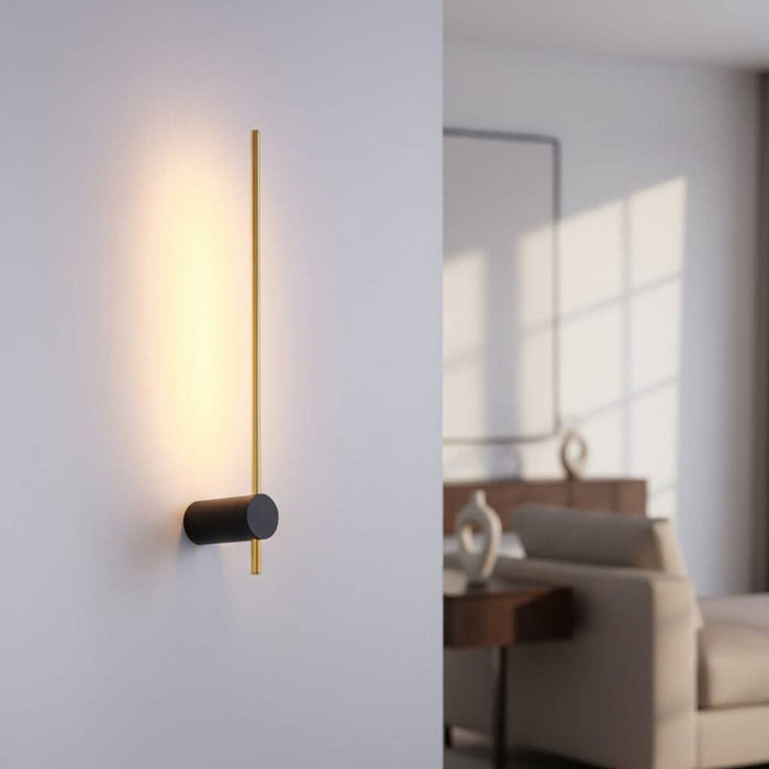 Black and gold interior LED wall sconce shown on a grey wall in a modern home