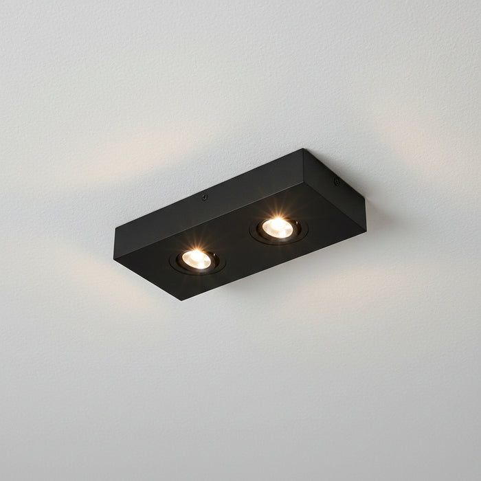black slim surface mount LED downlight installed on a white ceiling