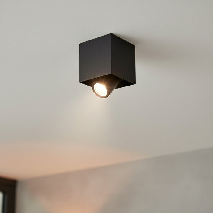 adjustable black surface downlight mounted on the ceiling in a modern house