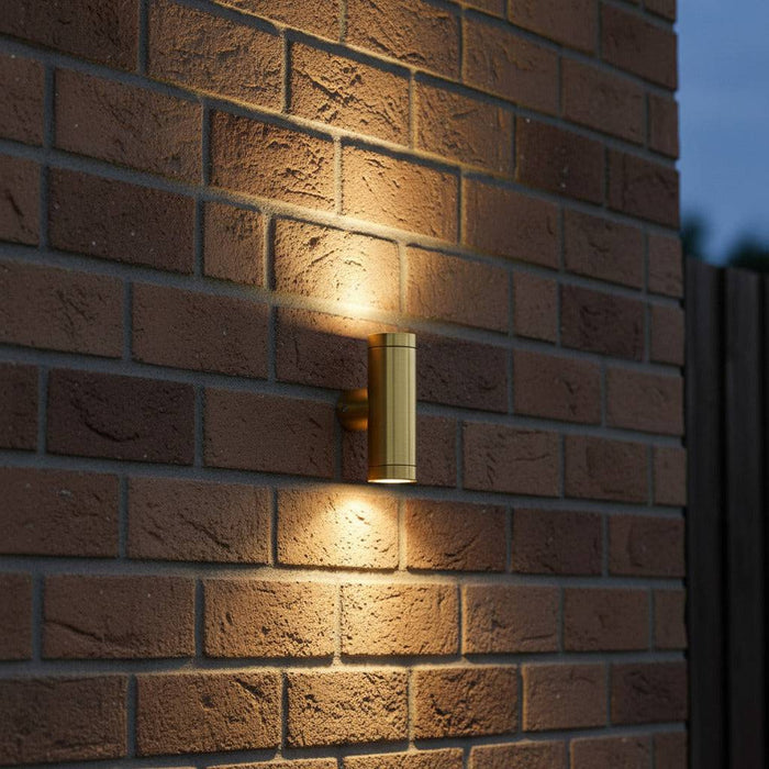 brass up down outdoor wall light mounted on a brick wall of a home