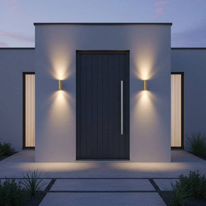 brass up down outdoor wall light installed either side of the front door of a home