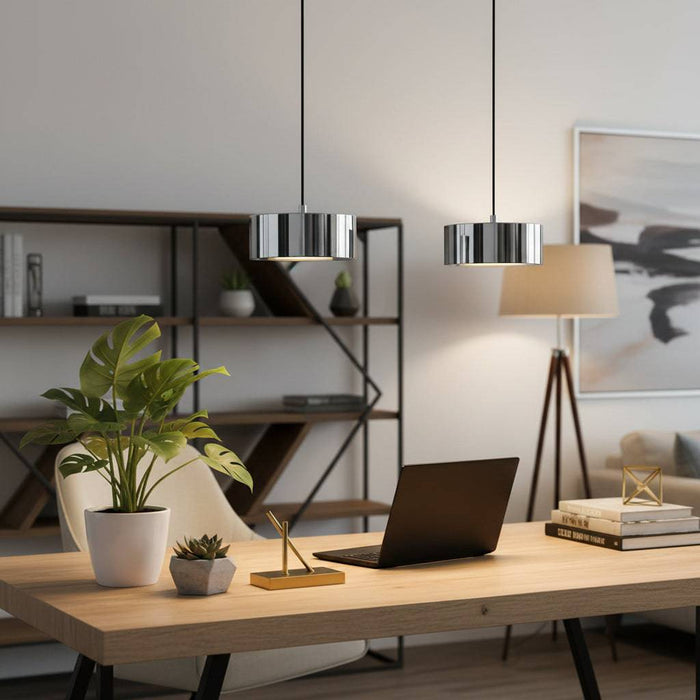 Chrome hanging ceiling light fixture above a desk with plants and pictures in  a modern home