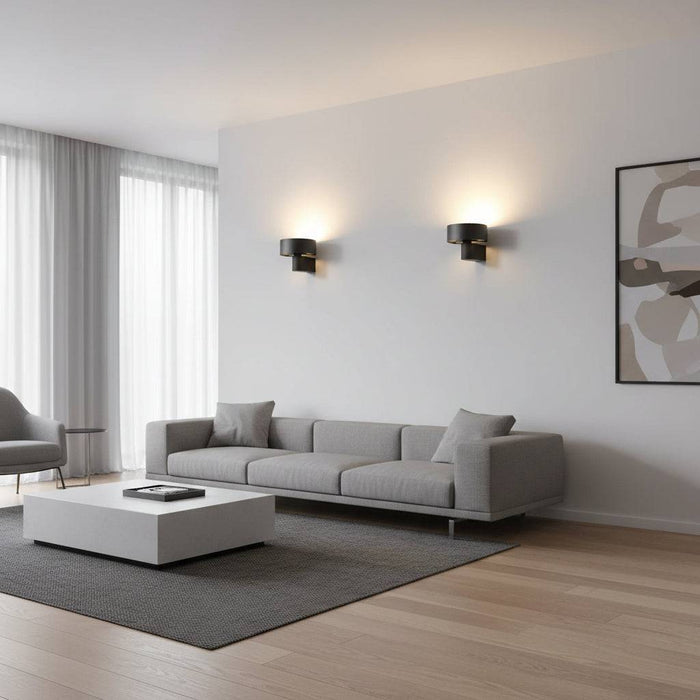 Black wall mounted interior light fixture on one wall above a sofa in a modern longe