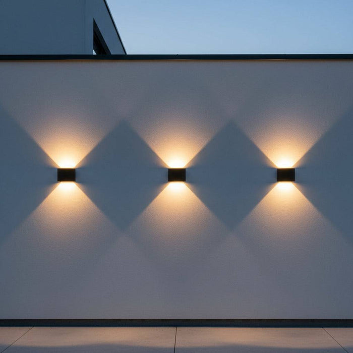 black up down outside light mounted in a row of three lights along a white exterior wall