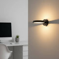 Black internal wall light on a grey wall next to a desk in a modern family home