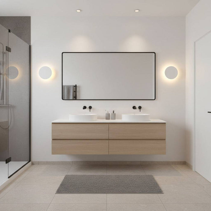 white modern bathroom wall sconce mounted either side of a mirror in a modern bathroom