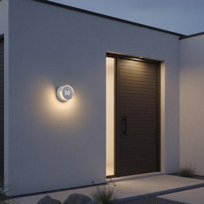 white LED house number sign mounted on the wall outside a modern home