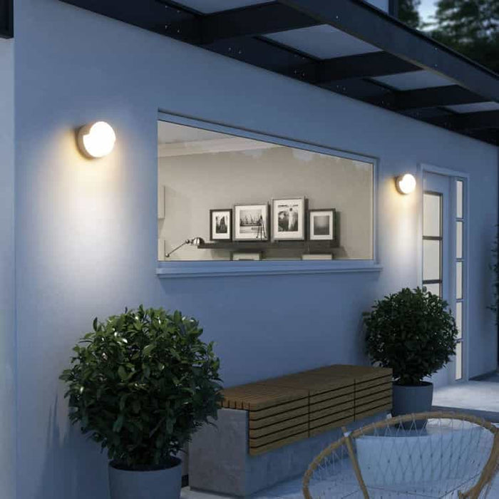 white modern outside wall light mounted either side of a window on a modern white home