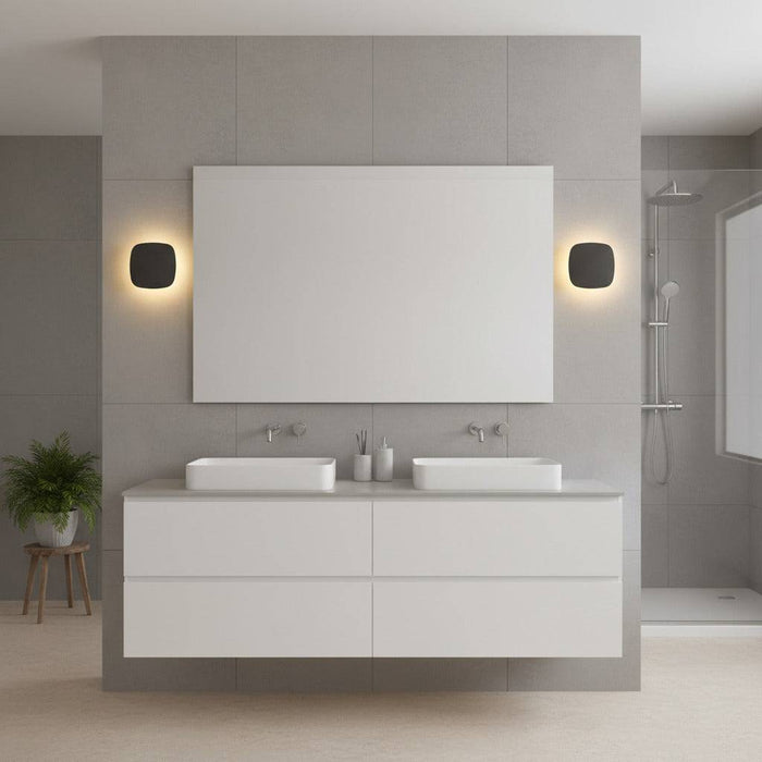 black vanity wall light shown mounted either side of a bathroom mirror in a modern bathroom