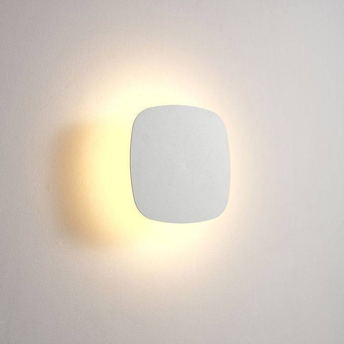 white bathroom wall mount light fixture shown mounted on a white wall