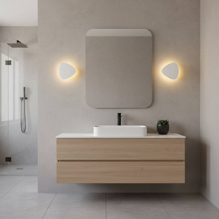 white wall mounted vanity light mounted either side of the mirror in a modern bathroom