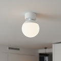 white globe ceiling light fixture mounted on the ceiling of a modern home