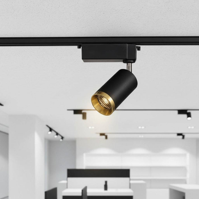 black and gold track lighting mounted on the ceiling in a shop