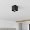 black square surface mounted downlight mounted on a white texture ceiling in a house