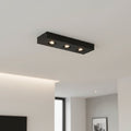 black surface mount downlight installed on the ceiling in a modern home