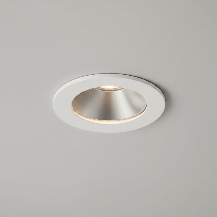white recessed LED downlight fitting on a light grey ceiling
