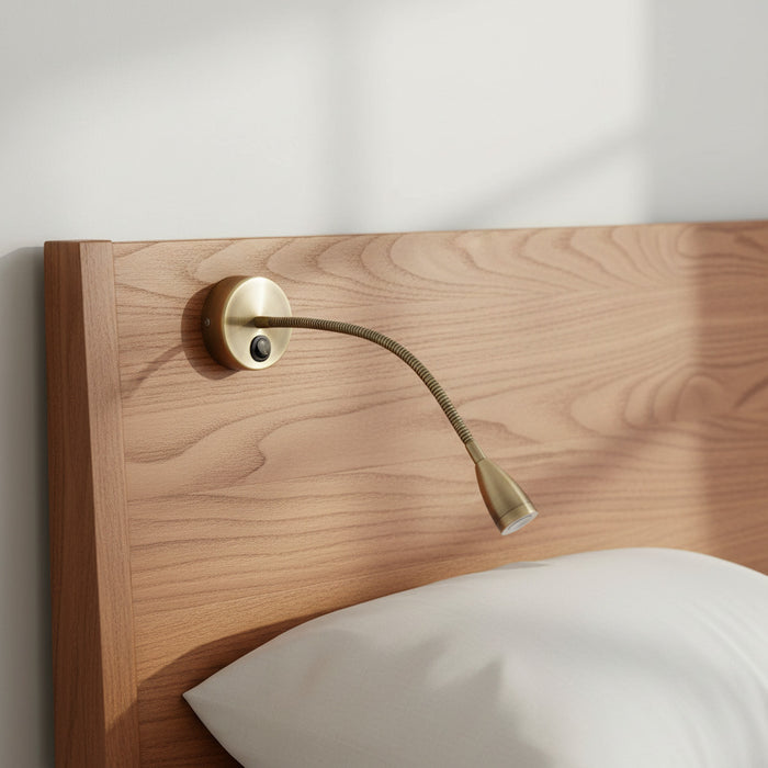 antique flexible bedside reading light fitted to a wood bed headboard