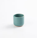 Antique teal blue green espresso cup on a white background