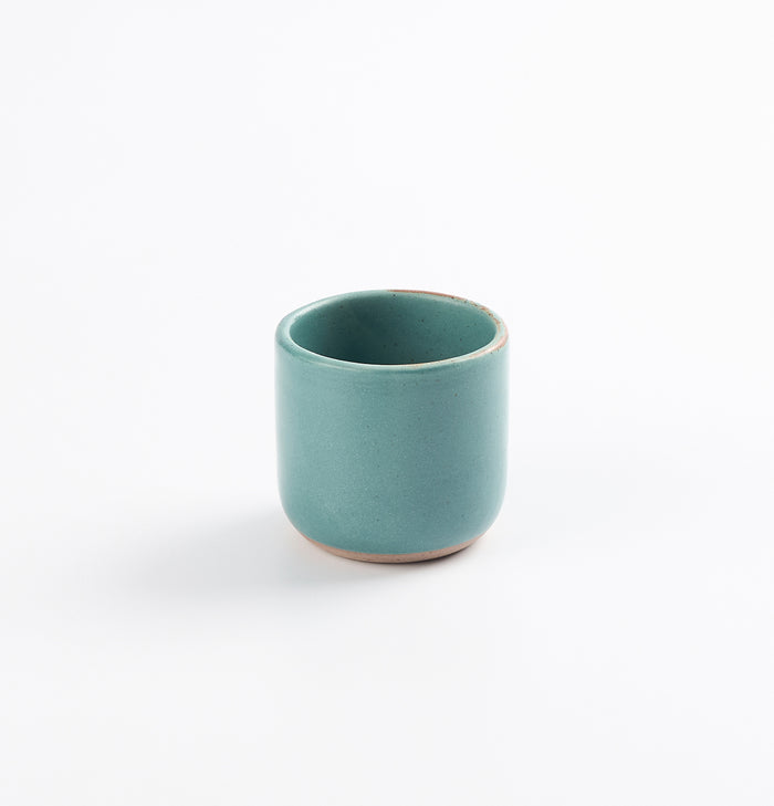 Antique teal blue green espresso cup on a white background