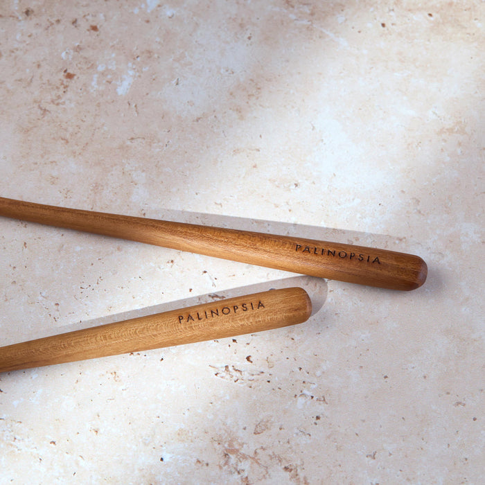 Close-up shot of the handles of teak wooden salad servers with Palinopsia labels on the handles.