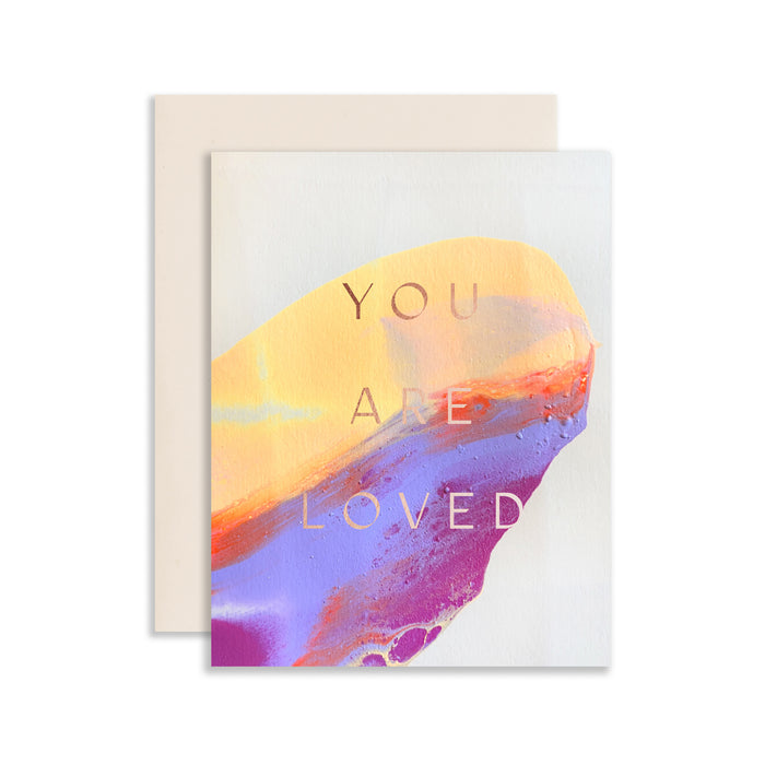 You Are Loved handmade purple artisanal greeting card with purple, yellow and pink paint swirls and an envelope on a white background.
