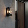 black outside sensor wall light mounted on the wall next to a front house door