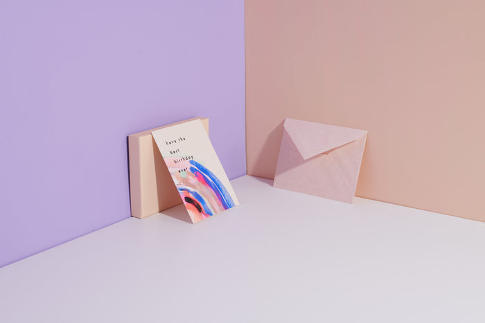 Have The Best Birthday Ever handmade purple artisanal greeting card with, pink and blue paint swirls and an envelope on a geometric background.