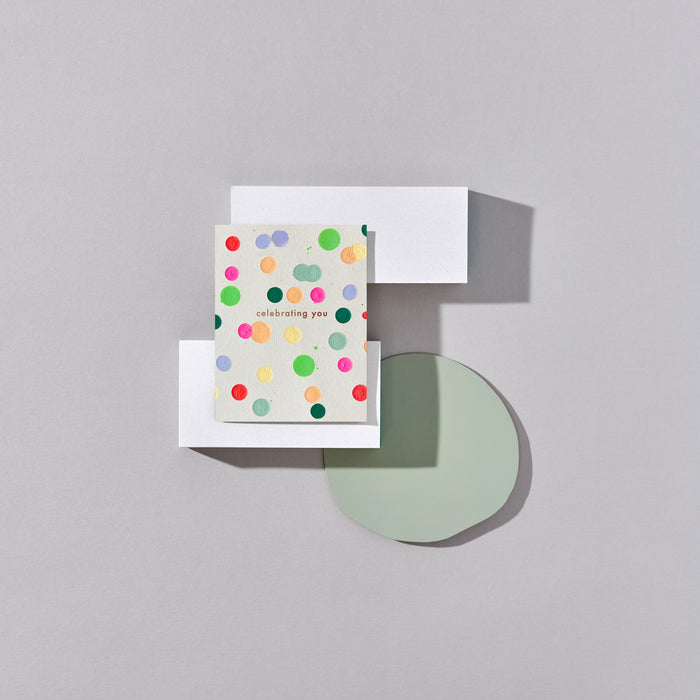 Celebrating You greeting card with colourful polka dot design on a geometric background