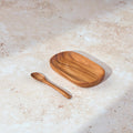 Palinopsia teak wooden tray and teak spoon on a light stone surface