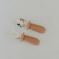 Set of children's fork and spoon with brown handles on a light gray background