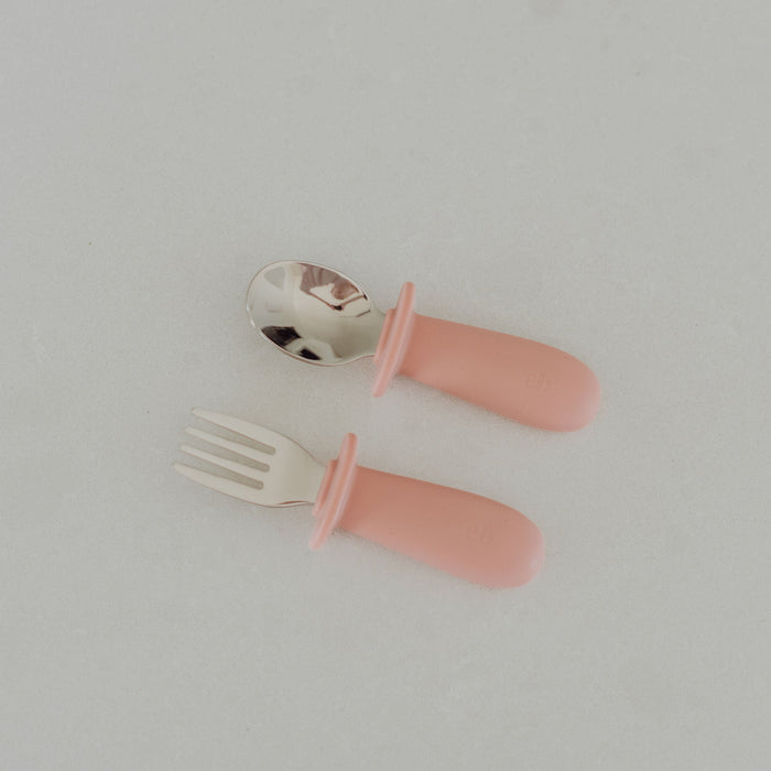 Pink children's fork and spoon set on a light gray background
