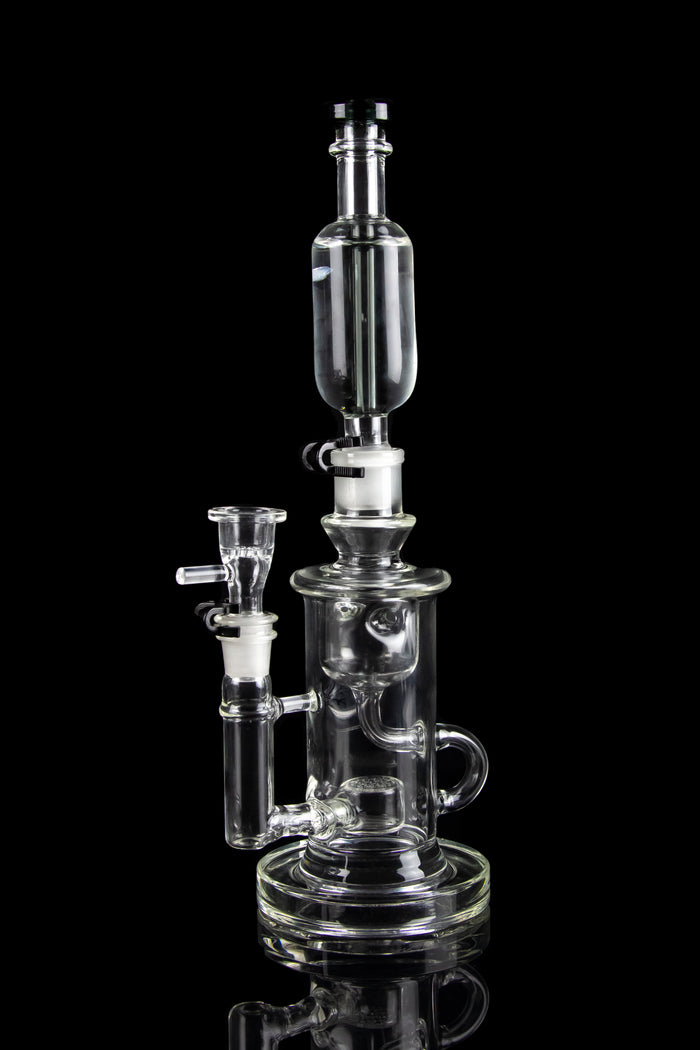 Clear glass water pipe (rig) with multiple chambers and attachments, isolated on a black background.