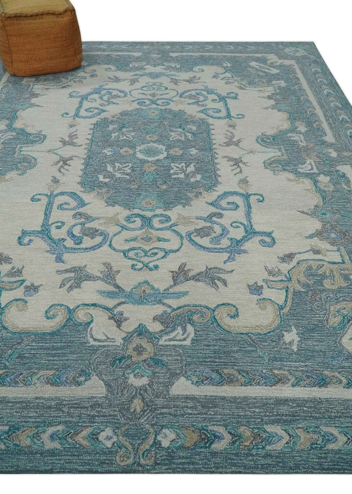 Ivory and blue hand-tufted wool rug with central medallion and decorative corner elements