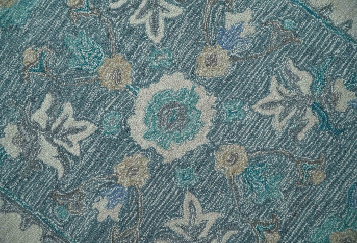 Close-up texture of ivory and blue hand-tufted wool rug with patterned rosettes
