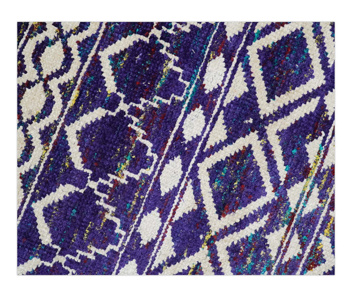 Close-up of hand-knotted silk rug showing blue, white, and multicolor diamond pattern