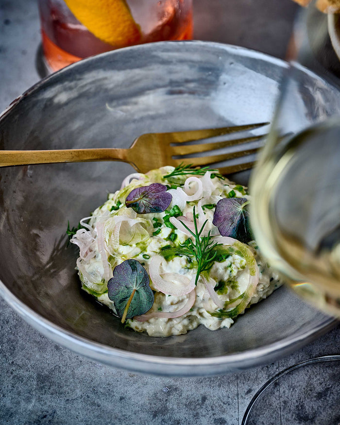 Potato salad in marbled bowl with a gloss of white wine