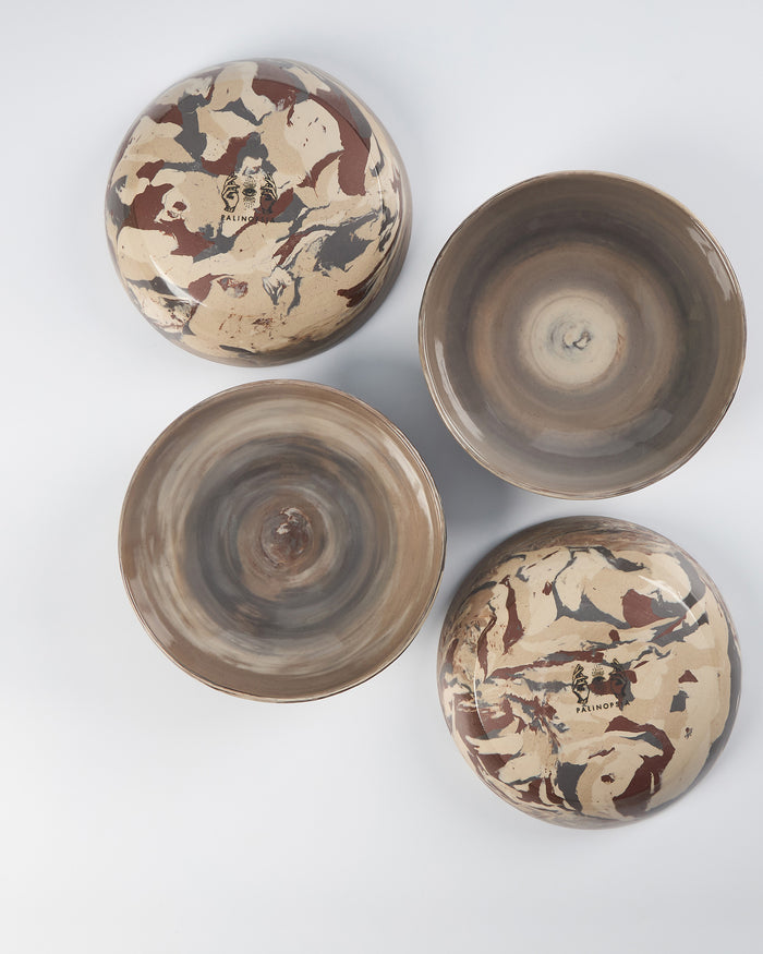 Set of four ceramic bowls with abstract patterns on a white background