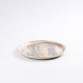 Round ceramic plate with a four colour marbled clay pattern on a white background by Palinopsia