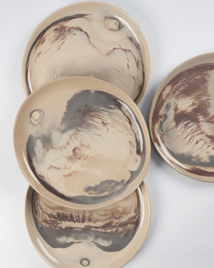 Set of ceramic plates with marbled design on a white background bird's eye shot.