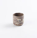 Ceramic espresso cup with four neutral natural clays in a marbled design on a white background by Palinopsia