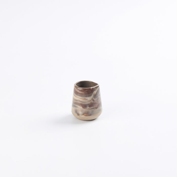Small ceramic milk and jus pitcher with marbled pattern on a white background