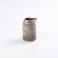 Ceramic hand pourer pitcher with marbled clay design on a white background