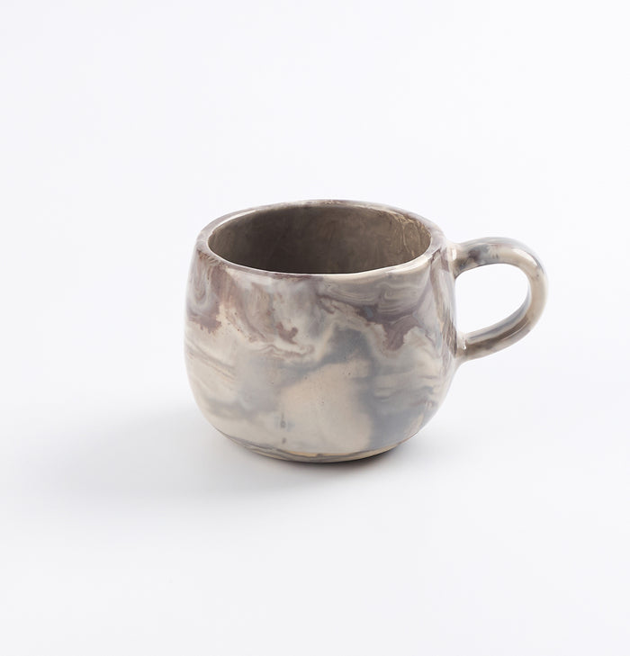 Ceramic mug with four neutral natural clays in a marbled design on a white background by Palinopsia