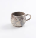 Ceramic mug with four neutral natural clays in a marbled design on a white background by Palinopsia