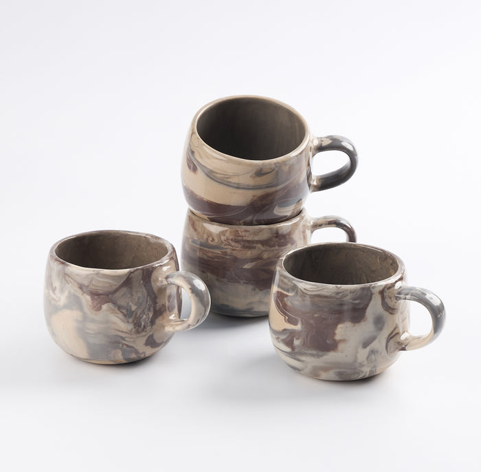 Set of four ceramic mugs with four neutral natural clays in a marbled design on a white background by Palinopsia