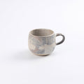 Stoneware ceramic mug with abstract marble pattern and a pure matte glaze on a white background