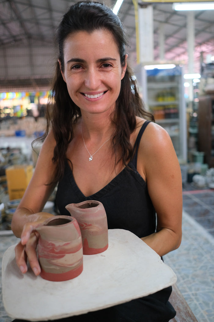 Tamara Bajic founder of Palinopsia Ceramics holding new clay shapes that will become small pitchers after firing