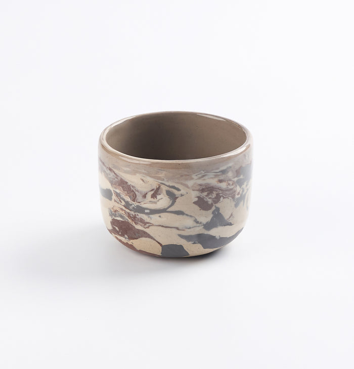 Ceramic cup with four neutral natural clays in a marbled design on a white background by Palinopsia
