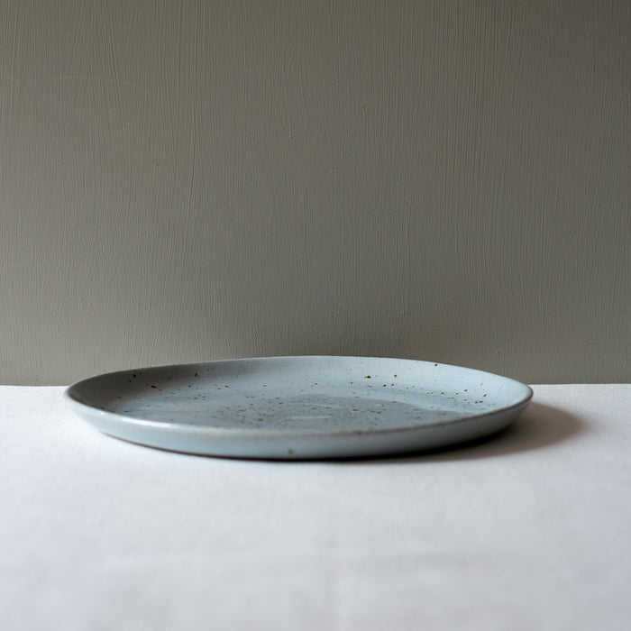 Side view of a large round handmade dinner plate